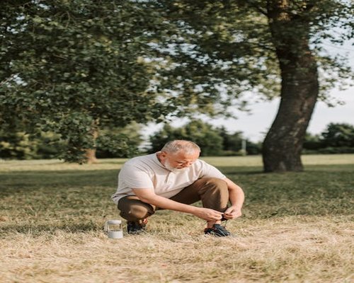 Woman tying shoelaces in nature morning light